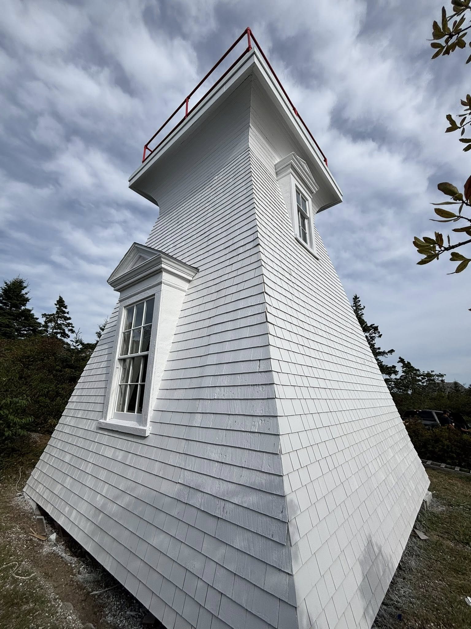 Shingled lighthouse with a crisp uniform painted finish after restoration