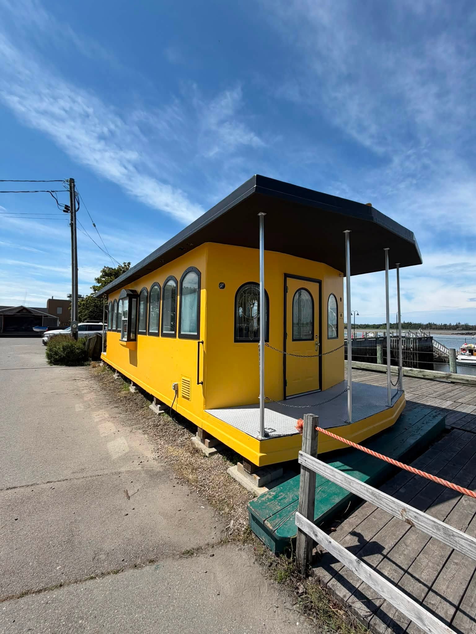 Railcar-style waterfront building repainted in bold bright yellow
