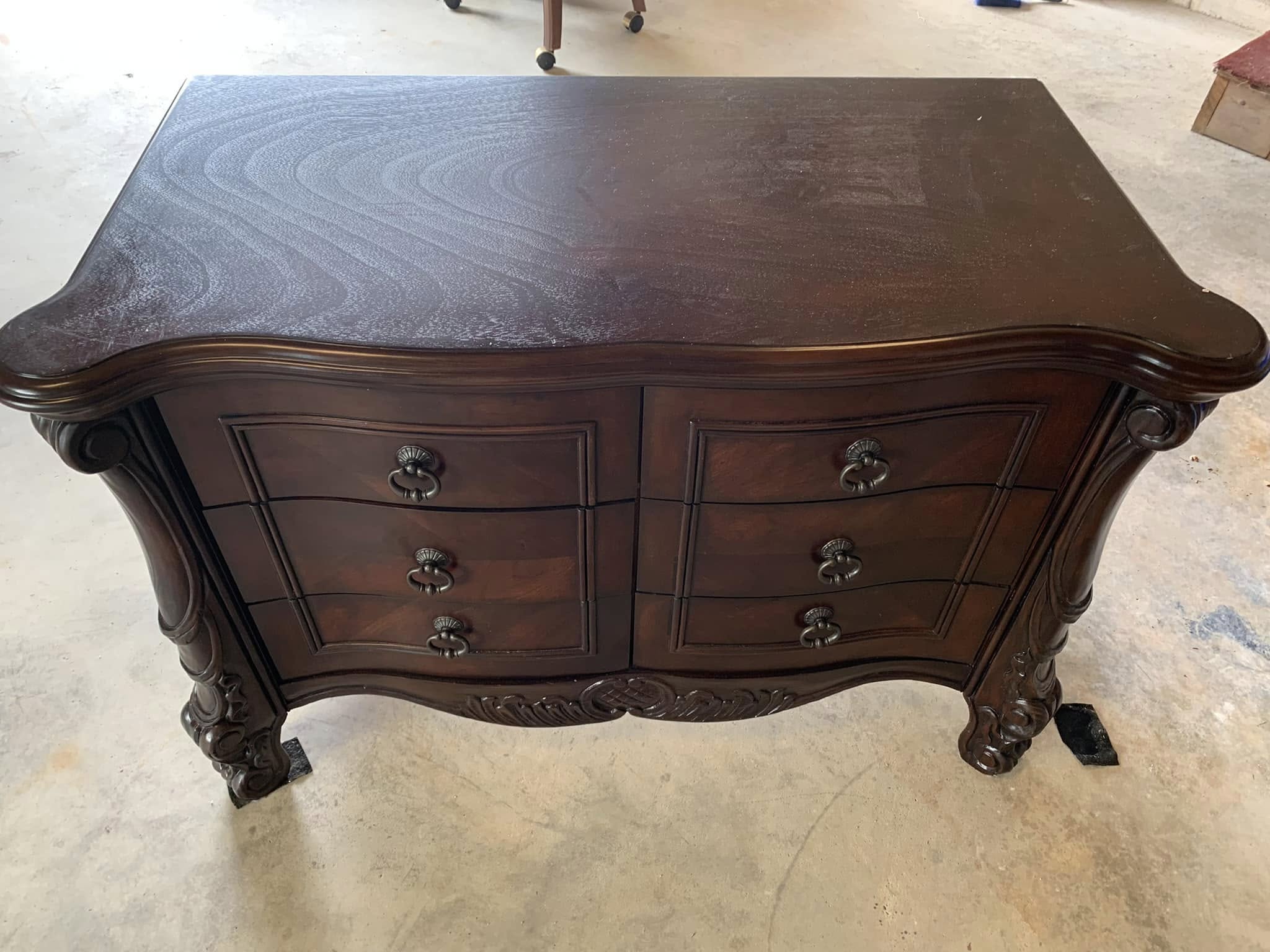 Ornately carved dresser in a dark stained finish before work