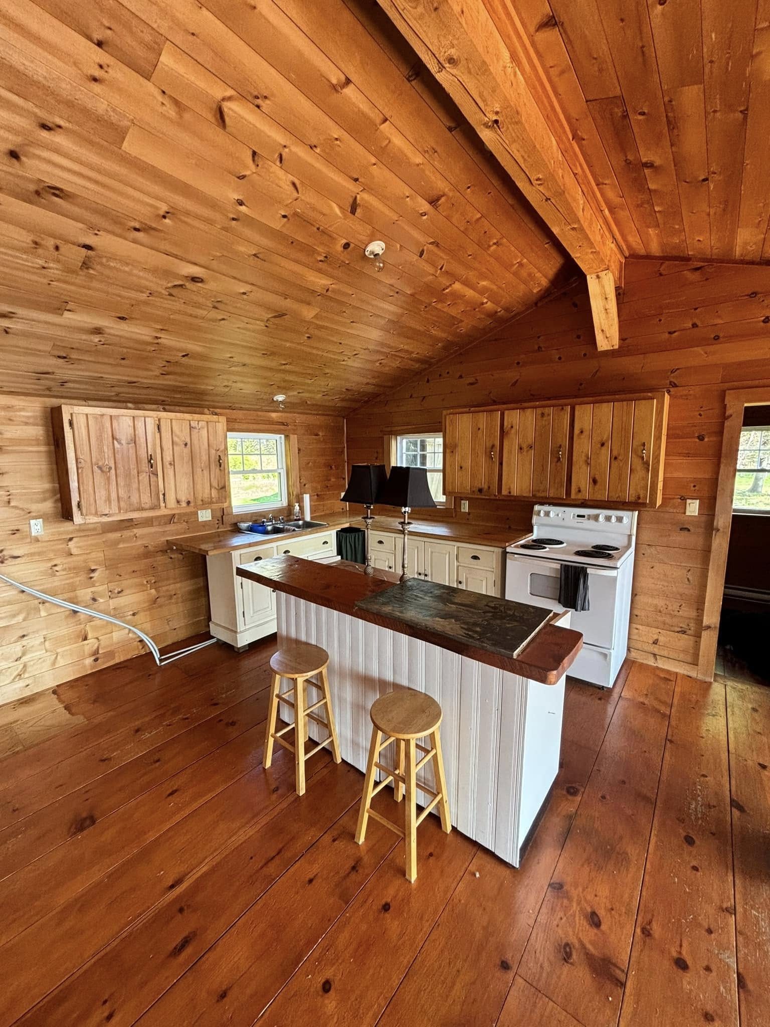 Pine-clad cottage interior with wood walls and ceiling before painting