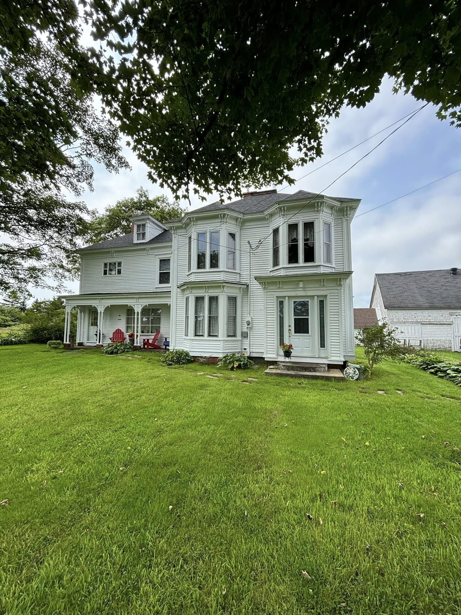 Two-storey farmhouse repainted in clean white clapboard