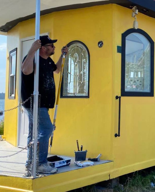 Dutch Painting Services founder painting a coastal building in Yarmouth, Nova Scotia